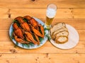 Boiled red crawfish on a white plate with green fennel on a wooden background.