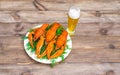 Boiled red crawfish on a white plate with green fennel on a wooden background.