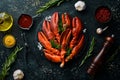 Boiled red lobster claws with spices and parsley on a black stone plate. On a black background. Rustic style. Royalty Free Stock Photo