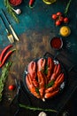 Boiled red lobster claws with spices and parsley on a black stone plate. On a black background. Rustic style. Royalty Free Stock Photo