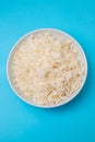 Boiled rice in a bowl on blue paper Royalty Free Stock Photo