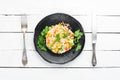 Boiled rice and vegetables. Risotto In a black plate. Top view.