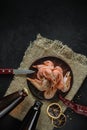 boiled shrimp on a clay plate with a pair of full lying bottles of beer on a burlap napkin on a black concrete surface. top view. Royalty Free Stock Photo
