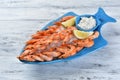 boiled shrimp with garlic sauce and lemon, on a bed of ice on a blue plate in the shape of a fish Royalty Free Stock Photo