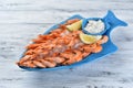 boiled shrimp with garlic sauce and lemon, on a bed of ice on a blue plate in the shape of a fish Royalty Free Stock Photo