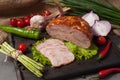 Boiled and smoked chicken roll on a wooden board decorated with fresh vegetables Royalty Free Stock Photo