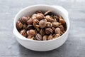 Boiled snails in the white bowl on ceramic background Royalty Free Stock Photo