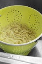 Boiled tagliatelle pasta straining in a colander