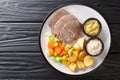 Boiled veal or Tafelspitz is the king of the beef dishes in Vienna close-up in a plate. horizontal top view