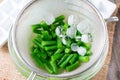 Boiled vegetables, green beans in a colander in ice water after blanching Royalty Free Stock Photo