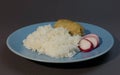 Boiled white rice with fish cutlet wrapped in bacon on a gray background blue plate. Baked fish meatball with garnish of rice and