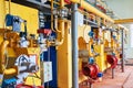 Boiler room with four large yellow cauldrons and red-blue burners.