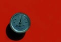 Boiler gauge for temperature and pressure on red background.
