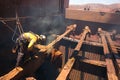 Boilermaker abseiler wearing safety harness, helmet commencing oxygen lancing