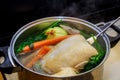 Boiling chicken broth with vegetables in steel pot on gas stove top Royalty Free Stock Photo