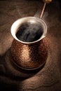 Boiling coffee in copper Turkish coffee brewing pot Royalty Free Stock Photo