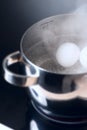Boiling eggs on cooktop side view Royalty Free Stock Photo