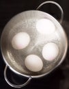 Boiling eggs on cooktop top view Royalty Free Stock Photo