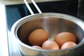 Boiling eggs in frying pan on an oven