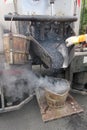 Boiling hot asphalt is filled into a bucket from an asphalt machine to fill a pothole. Road construction, road rehabilitation, as