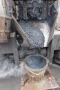 Boiling hot asphalt is filled into a bucket from an asphalt machine to fill a pothole. Road construction, road rehabilitation, as