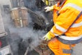 Boiling hot asphalt is filled into a bucket from an asphalt machine to fill a pothole. Road construction, road rehabilitation, asp