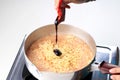 Boiling Korean Instant Noodle Spicy Ramyun on Sauce Pan, Pour Ramen Spiced Paste to the Pan Royalty Free Stock Photo