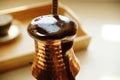 Boiling over coffee in copper cezve close-up. Turkish coffee Royalty Free Stock Photo