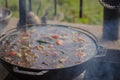 Boiling soup in pan on fire. Kettle on fire. Touristic food. Main dish preparation. Boiled meat soup. Pot on campfire. Royalty Free Stock Photo
