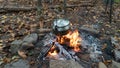 Boiling tea with a pot over a Bushcraft campfire. Primitive survival lean to shelter in the Blue Ridge Mountains of Asheville, Nor Royalty Free Stock Photo