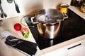Boiling water on ceramic hob, spaghetti, green pesto, red kitchen timer
