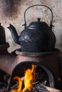 Boiling water on clay stove with an old cast iron kettle, countryside cooking utensils Royalty Free Stock Photo