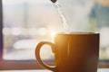 Boiling water pouring into a cup from kettle, making morning coffee Royalty Free Stock Photo