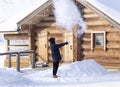 Boiling water splashed out of a mug in the cold minus 35 degrees turns into steam. a teenager explores the transformation of