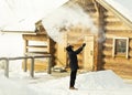 Boiling water splashed out of a mug in the cold minus 35 degrees turns into steam. a teenager explores the transformation of