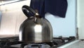 Boiling water in a tea pot on a gas stove. Steel kettle boiling on a gas stove, home cooking