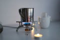 Boils water for coffee on a small tourist stove with dry fuel in complete darkness during a power and gas outage at home