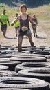 BOISE, IDAHO/USA - AUGUST 10: Runner 10951 does high knees to get past the tire obstacle at the The Dirty Dash in Boise, Idaho on