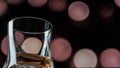 Bokeh background with an alcoholic drink, a glass with whiskey on a background of red circles Royalty Free Stock Photo