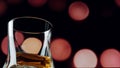 Glass with whiskey on a background of red circles bokeh, alcohol on the bar Royalty Free Stock Photo