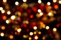 Bokeh in a circle on a dark background. Blurred christmas wreath. Abstract photograph. Yellow, red lights on a black background