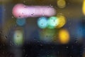 Bokeh city lights, night. Abstract blurred colorful background. View through glass window with rain drops Royalty Free Stock Photo