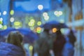 Bokeh city lights, night. Abstract blurred people under the umbrellas. Rainy evening in the city street at autumn Royalty Free Stock Photo