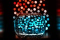 Bokeh and glass vase with drops on black background. Magic picture, fabulous color effects.. Royalty Free Stock Photo