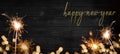 bokeh golden flares and sparkler isolated on black wooden texture - Holiday New Year\'s Eve Silvester New Year 2024 Party