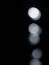 Bokeh lights on black background, shot of flying drops of water in the air, defocused water drops levitation on dark