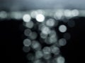 Bokeh lights on black background, shot of flying drops of water in the air, defocused water drops levitation on dark Royalty Free Stock Photo