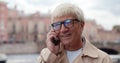 Bokeh shot of senior man talking on cellphone outdoors Royalty Free Stock Photo