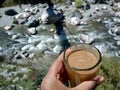 Bokeh shot of tea served in a glass with river and valley background