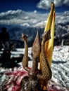 Bokeh shot of the trishul( a weapon of Lord Shiva made of brass) with snow and mountains background.